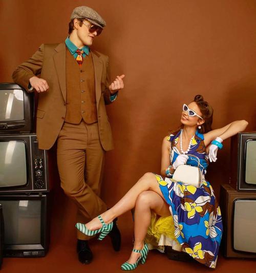 Пара у класичному ретро-одязі 50-х років: коричневий костюм-трійка та квіткова сукня