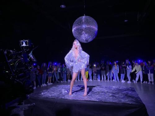 Дівчина у сріблястій сукні з торочками під диско-кулею — образ у стилі диско 80-х