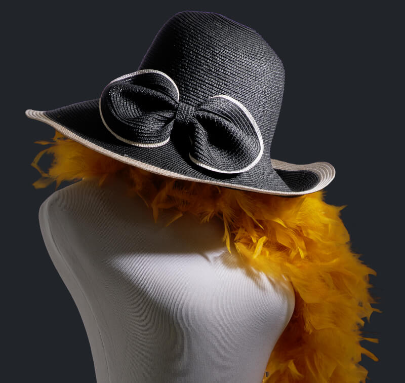 Жіночий манекен з чорною шляпою та жовтим боа